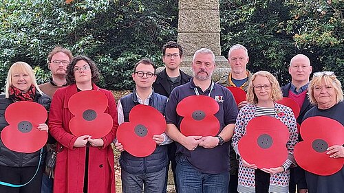 Cllrs and others holding large poppies 