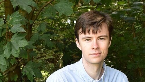 George Jezard standing in front of greenery